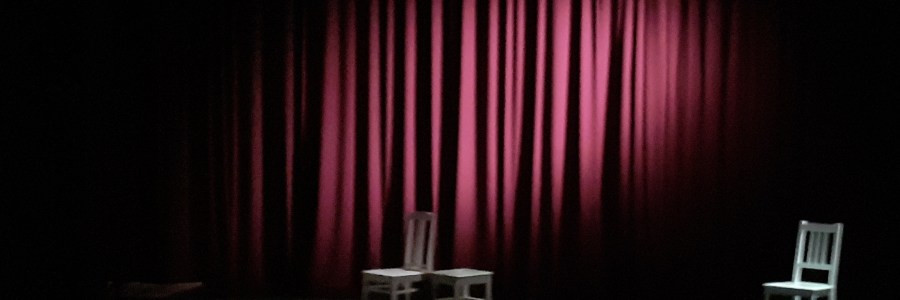 punainen esirippu ja kolme tuolia lavalla