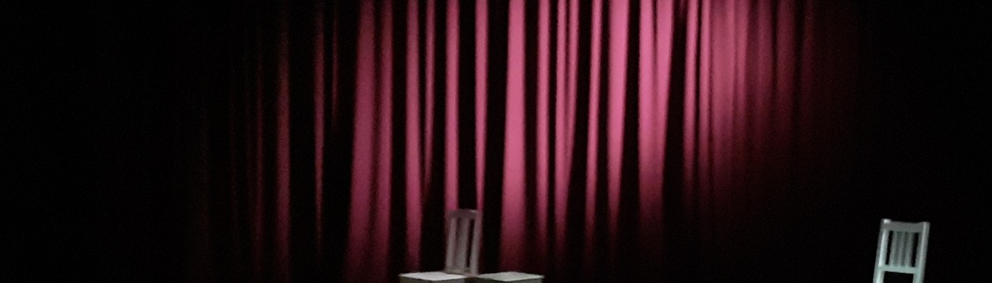 punainen esirippu ja kolme tuolia lavalla