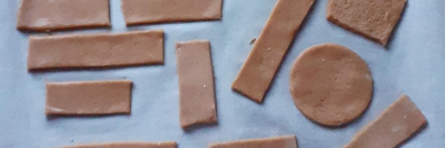 leivinpaperin päällä paistamattomia nelikulmaisia ja pyöreitä pipareita