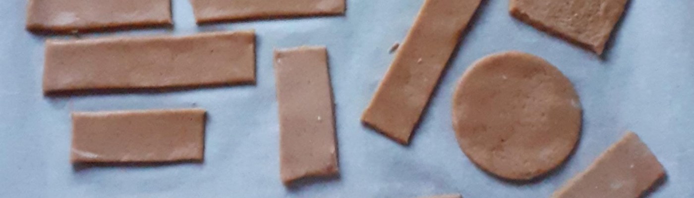 leivinpaperin päällä paistamattomia nelikulmaisia ja pyöreitä pipareita