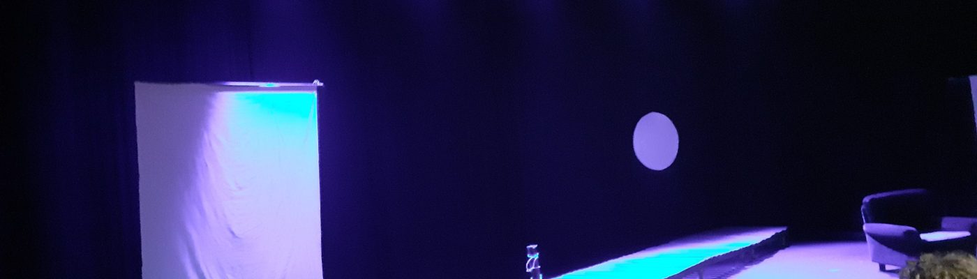 Teatterilavastus, jossa keskiössä on laituri ja sen takana oleva kuu