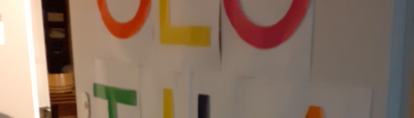 Valkoinen ovi, johon on kiinnitetty värikkäin kirjaimin kirjoitettue teksti: olotila