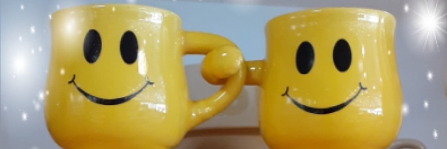 Jalalliset hymiökahvikupit, joista toinen pitää kahvallaan kiinni toisen kupin korvasta.