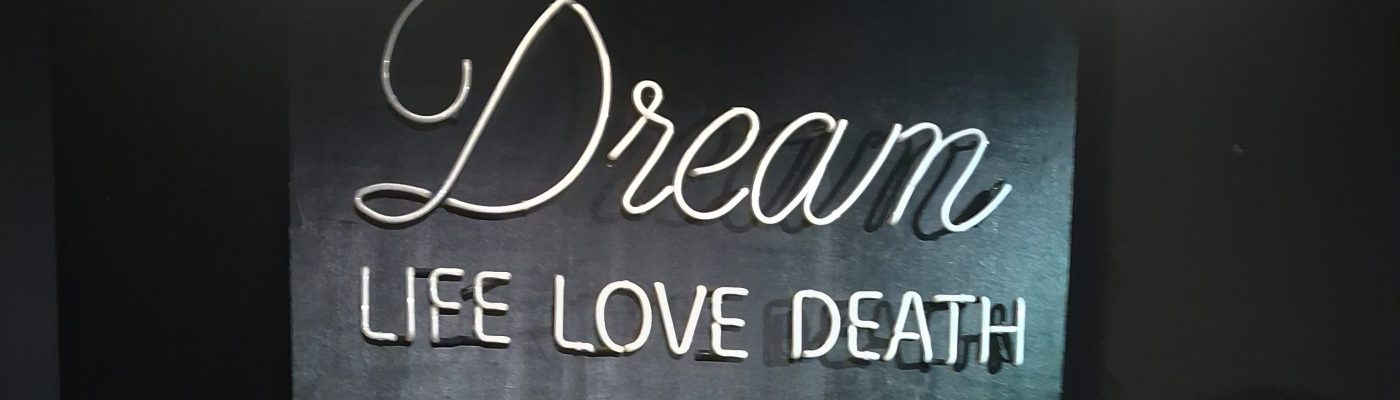 Neonvalokyltti, jossa sanati: Dream, Life, Love, Death.