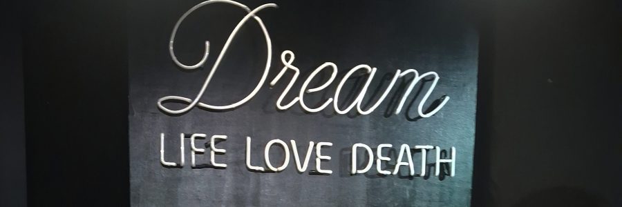 Neonvalokyltti, jossa sanati: Dream, Life, Love, Death.